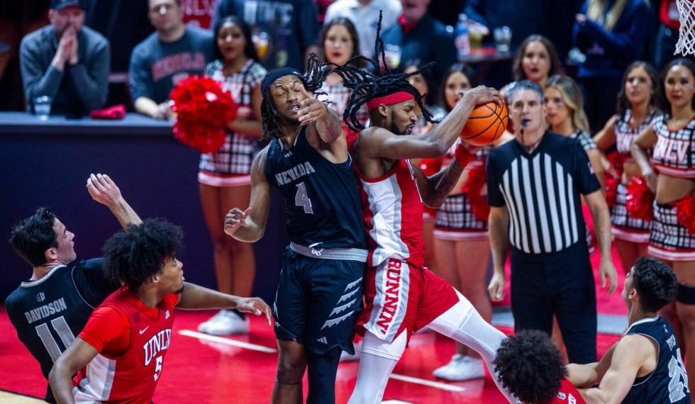 UNLV Rebels forward Kalib Boone (10) pulls down a rebound over UNR forward Tre Coleman (4) duri ...