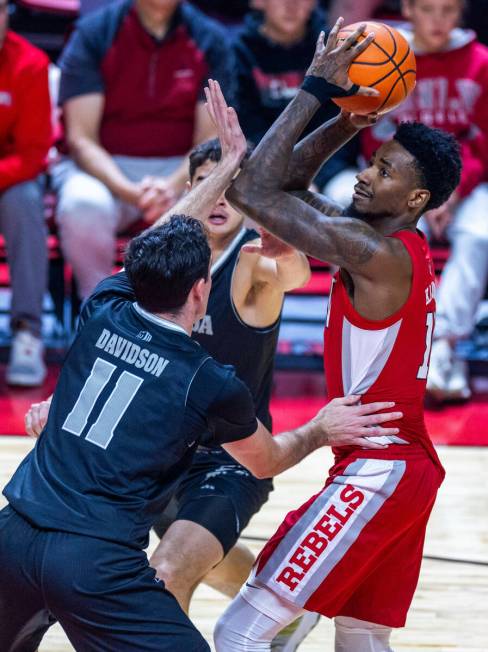 UNLV Rebels forward Kalib Boone (10) looks to shoot over UNR forward Nick Davidson (11) during ...