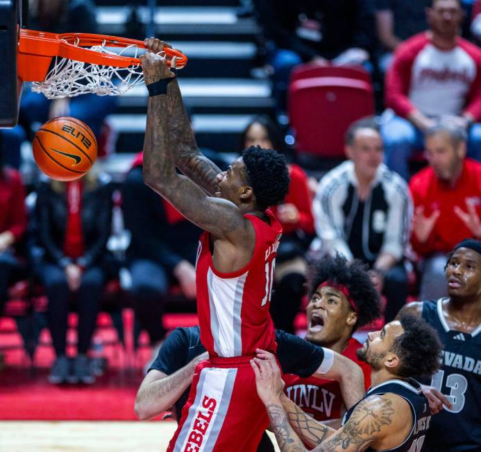 UNLV Rebels forward Kalib Boone (10) dunks the ball as UNR forward K.J. Hymes (42) looks on dur ...