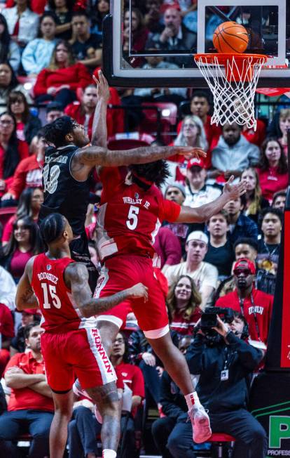 UNR guard Kenan Blackshear (13) scores against UNLV Rebels forward Rob Whaley Jr. (5) during th ...