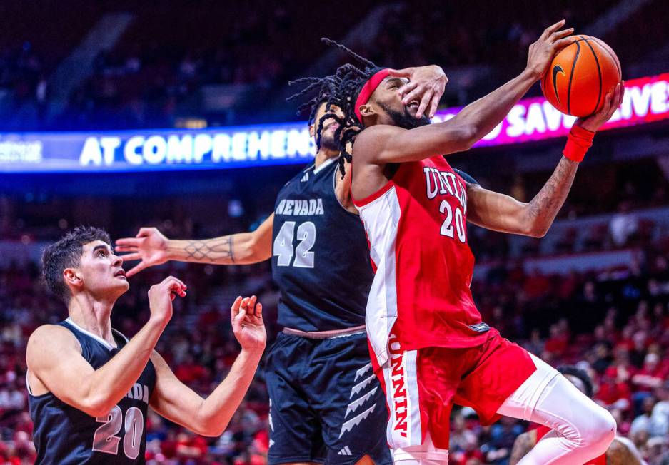 UNLV Rebels forward Keylan Boone (20) gets a hand to the face and a foul on the drive from UNR ...