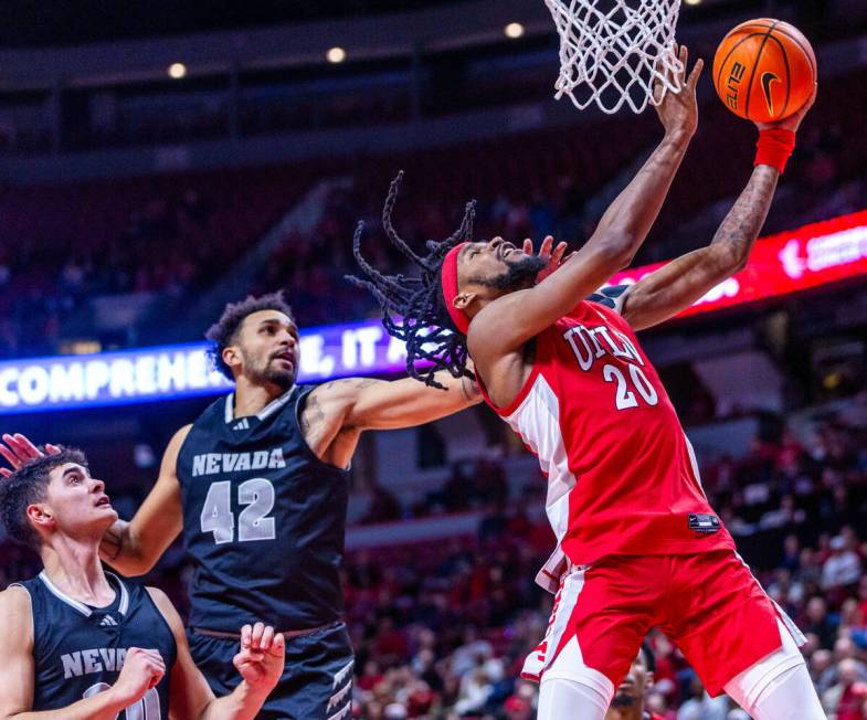 UNLV Rebels forward Keylan Boone (20) gets a hand to the face and a foul on the drive from UNR ...