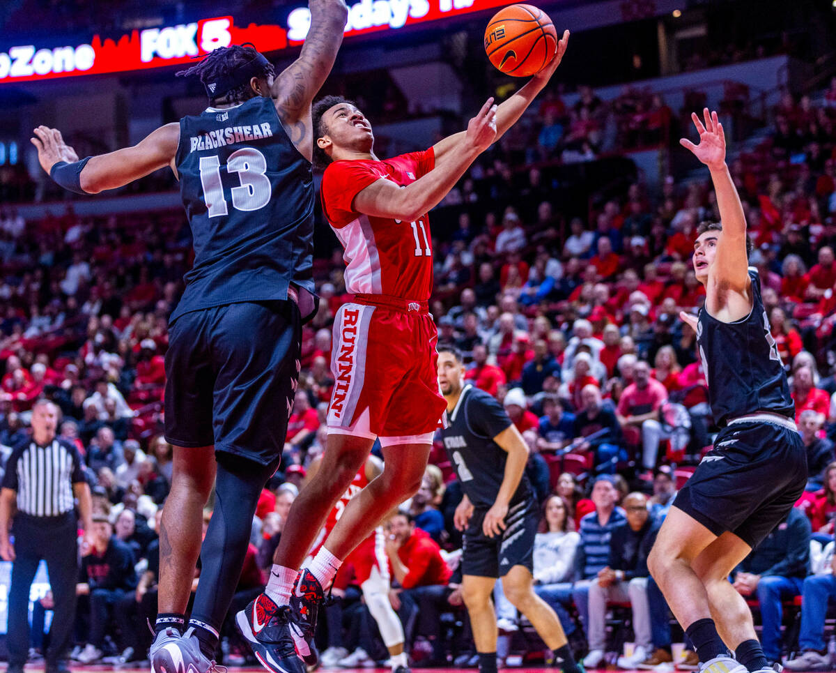 UNLV Rebels guard Dedan Thomas Jr. (11) gets inside of UNR guard Kenan Blackshear (13) for a sh ...