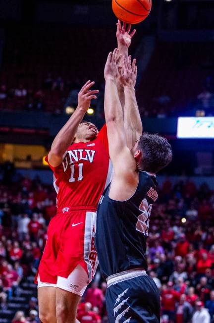 UNLV Rebels guard Dedan Thomas Jr. (11) elevates to shoot over UNR guard Daniel Foster (20) dur ...