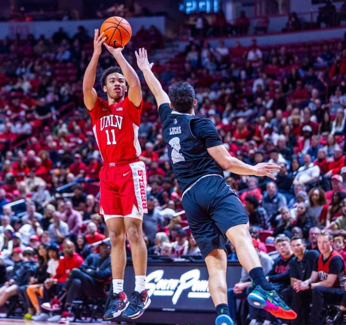 UNLV Rebels guard Dedan Thomas Jr. (11) elevates to shoot over UNR guard Jarod Lucas (2) during ...