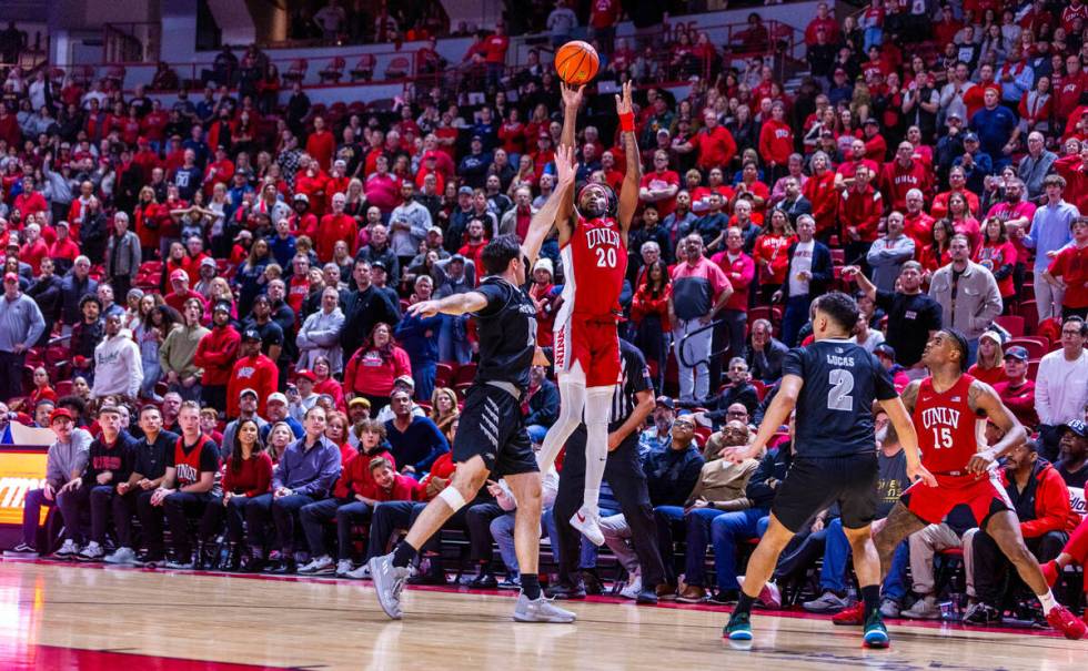 UNLV Rebels forward Keylan Boone (20) gets off a failed three-point shot over UNR forward Nick ...