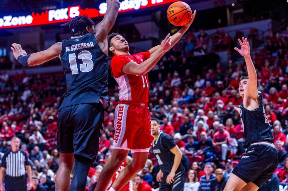 UNLV Rebels guard Dedan Thomas Jr. (11) gets inside of UNR guard Kenan Blackshear (13) for a sh ...