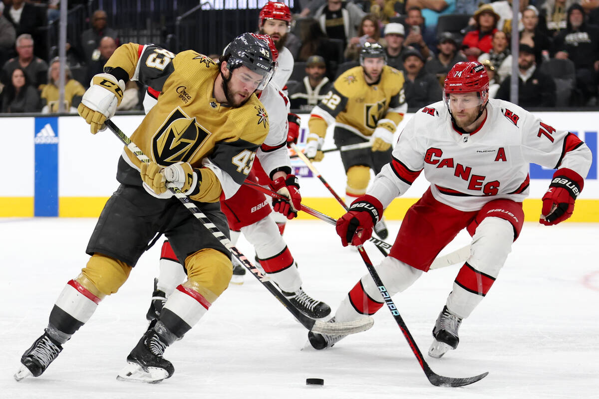 Golden Knights center Paul Cotter (43) takes the puck up the ice against Hurricanes defenseman ...