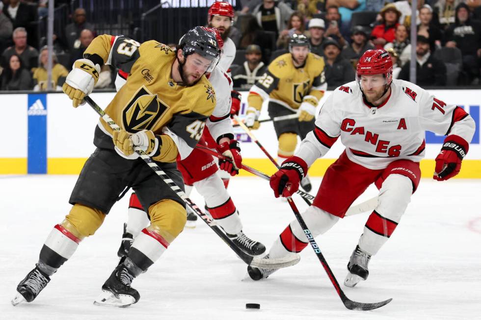 Golden Knights center Paul Cotter (43) takes the puck up the ice against Hurricanes defenseman ...