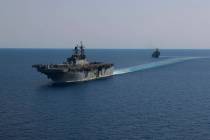 In this photo released by the U.S. Navy, the amphibious assault ship USS Bataan, front, and the ...