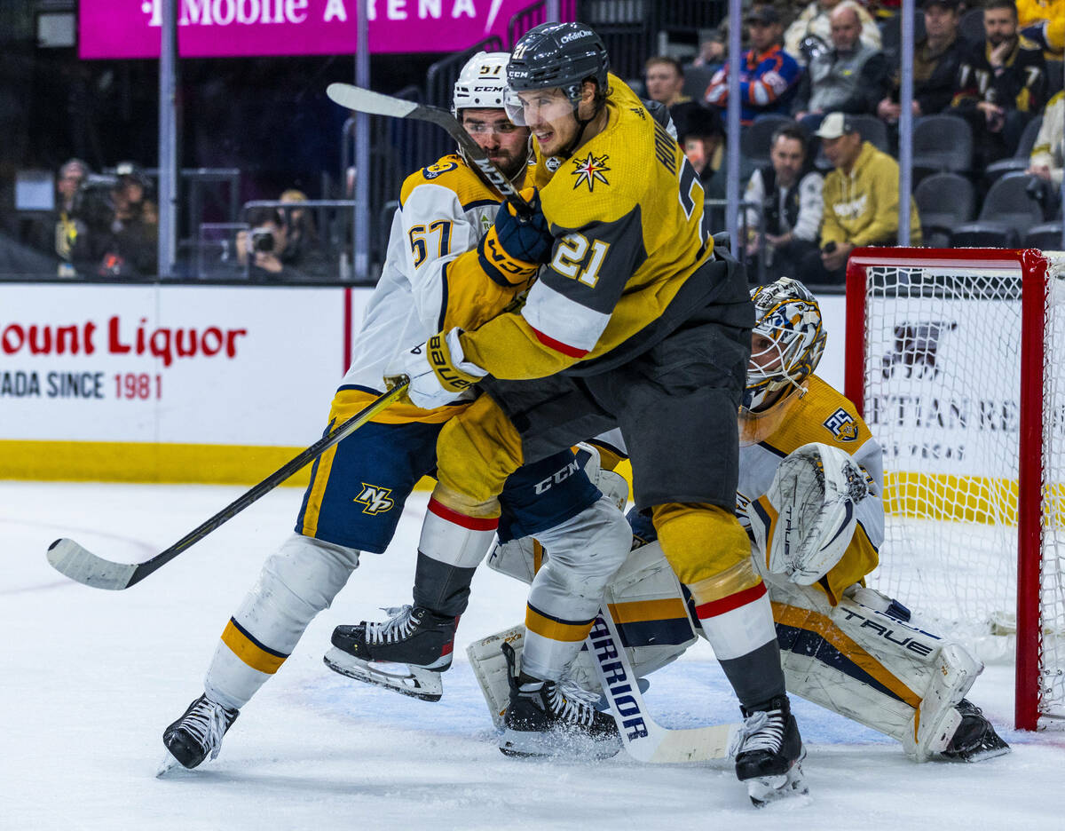 Golden Knights center Brett Howden (21) and Nashville Predators defenseman Dante Fabbro (57) ba ...