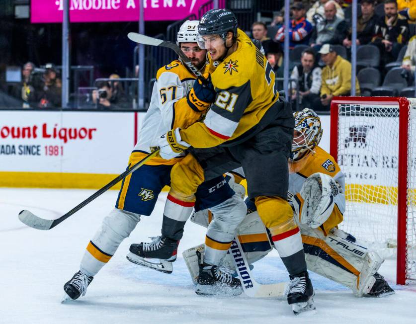 Golden Knights center Brett Howden (21) and Nashville Predators defenseman Dante Fabbro (57) ba ...