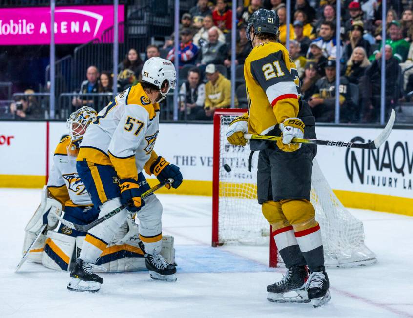 Golden Knights center Brett Howden (21) and Nashville Predators defenseman Dante Fabbro (57) lo ...