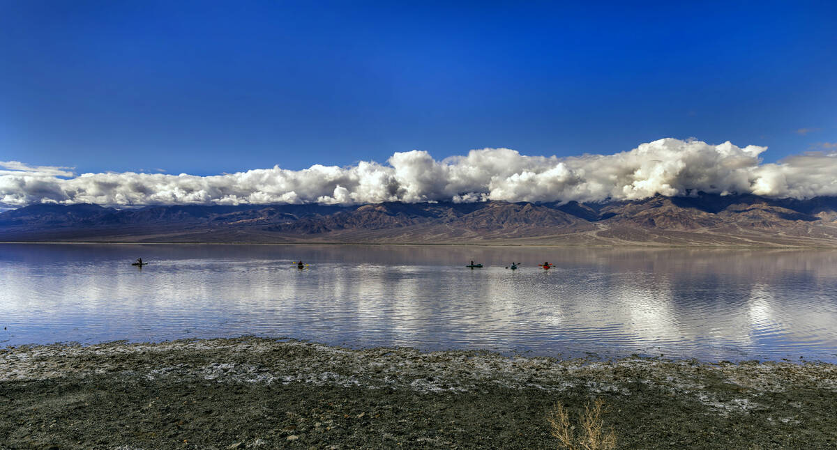 People paddle on kayaks on the temporary Lake Manly at Badwater Basin in Death Valley National ...