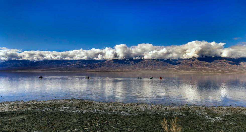 People paddle on kayaks on the temporary Lake Manly at Badwater Basin in Death Valley National ...