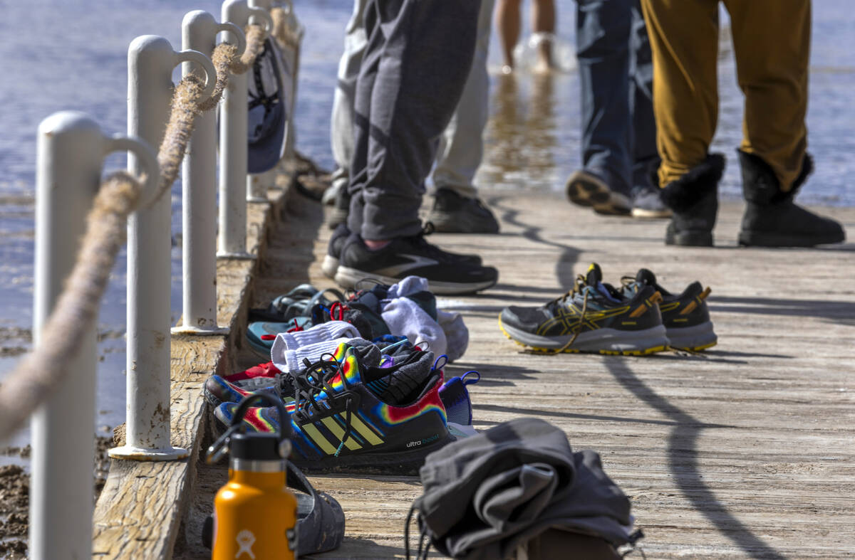 People wander in and out of the water on the temporary Lake Manly at Badwater Basin in Death Va ...