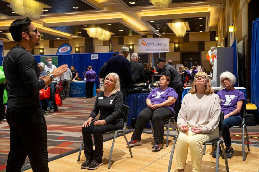 Attendees of the 2002 Aging Wellness Expo participate in a mindfulness session with instructor ...