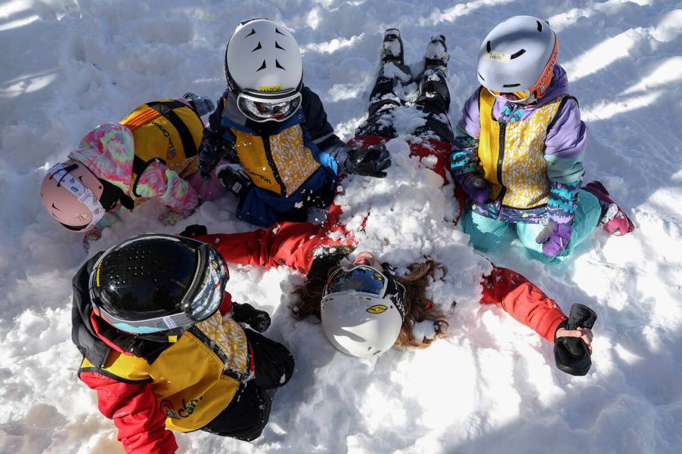 Instructor Cierrah Touchstone’s students bury her in the snow during a ski lesson at Lee Cany ...