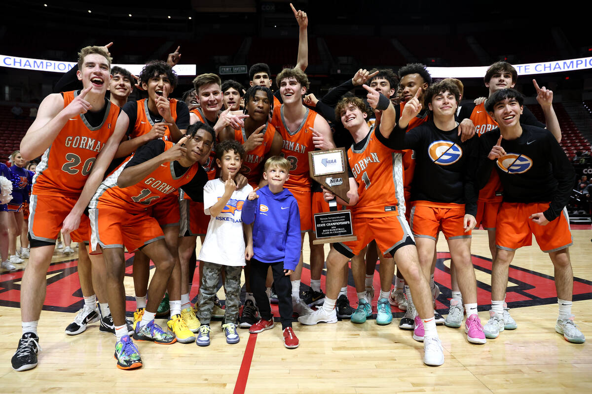 Bishop Gorman poses for photos after defeating Coronado in the Class 5A boys basketball state c ...