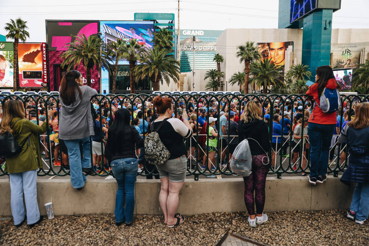 People film from the sidewalks as runners get ready to take to the Strip during the Rock &#x201 ...