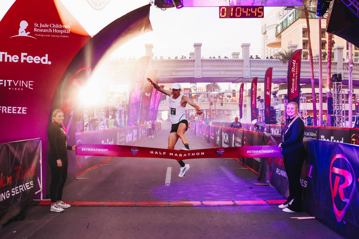 Andy Wacker jumps over the finish line ribbon after coming in first place for the me’s h ...