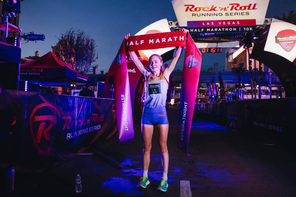 Alice Wright raises the half marathon finishing line ribbon after coming in first for the women ...