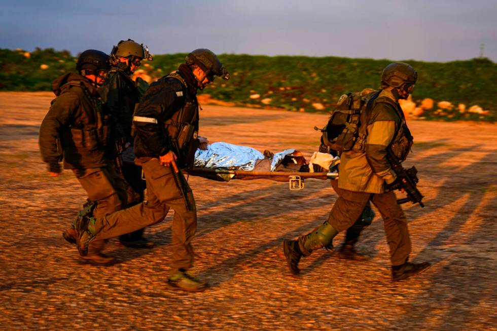 Israeli soldiers run as they carry a stretcher towards a military helicopter during an exercise ...