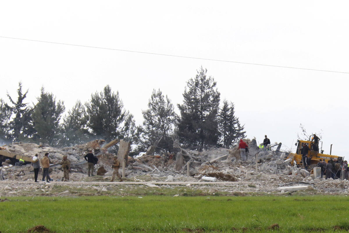 Lebanese soldiers and civil defence workers gather near a destroyed warehouse which was attacke ...