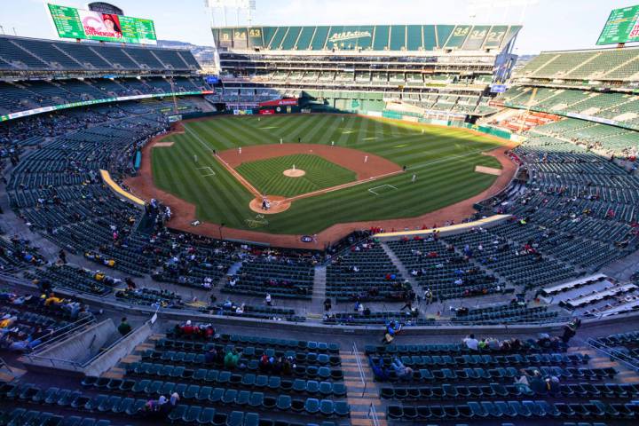 Fans watch a baseball game between the A’s and the Cincinnati Reds at the Oakland Colise ...