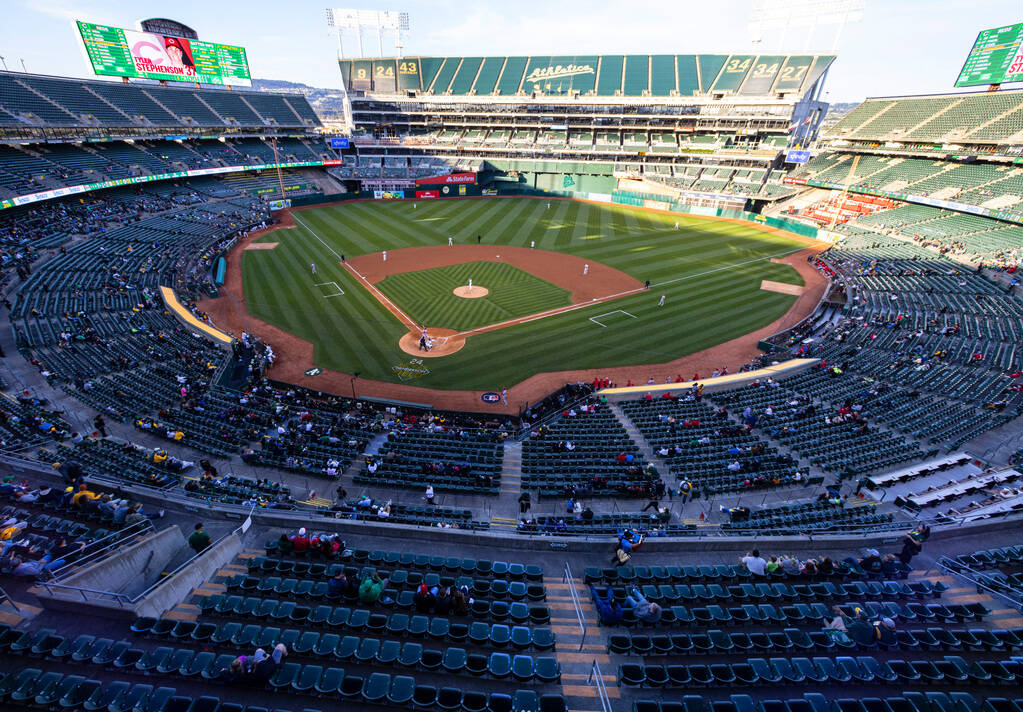 Fans watch a baseball game between the A’s and the Cincinnati Reds at the Oakland Coliseum, o ...