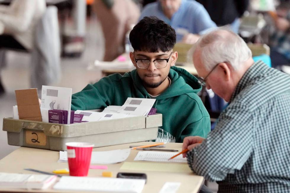 Election workers sort through absentee ballots, Tuesday, Feb. 27, 2024, in Warren, Mich. Michi ...