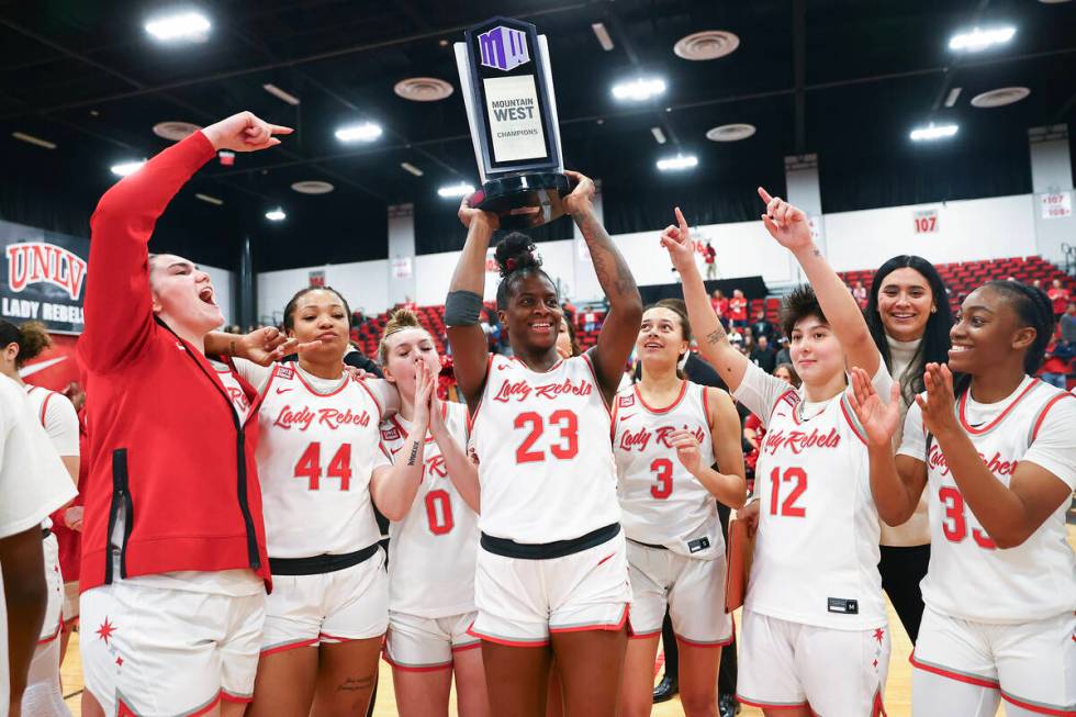 The UNLV Lady Rebels hold up their Mountain West championship trophy after clinching the title ...