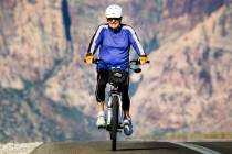 John Taube, 79, rides his bicycle along state Route 159 in the Red Rock Canyon National Preserv ...