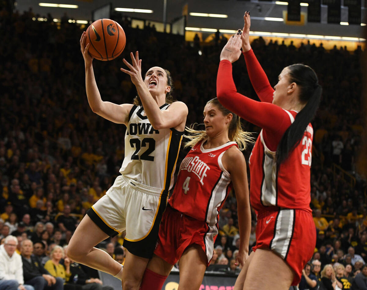 Iowa guard Caitlin Clark (22) drives to the basket under pressure from Ohio State guard Jacy Sh ...