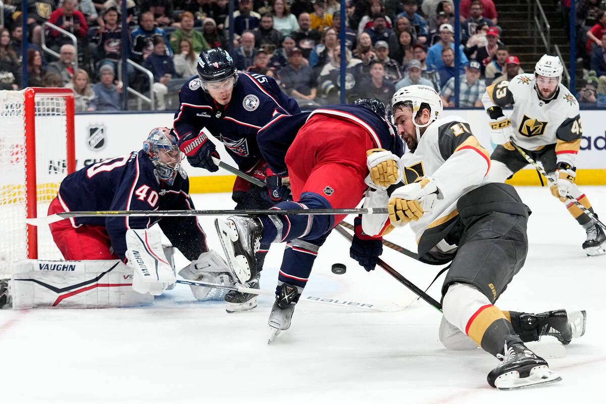 Vegas Golden Knights center Nicolas Roy, front right, falls as he battles for the puck with Col ...