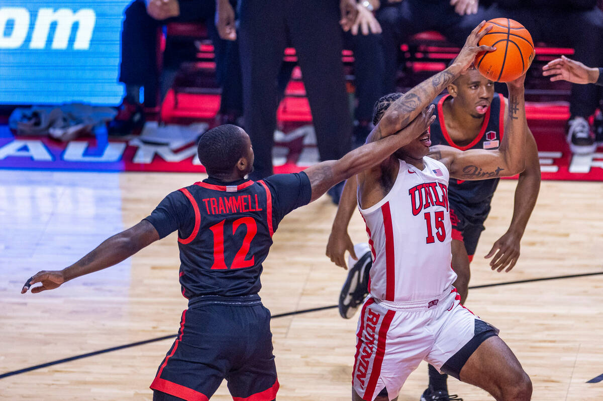 UNLV guard Luis Rodriguez (15) takes a hand to the face as he drives from San Diego State Aztec ...