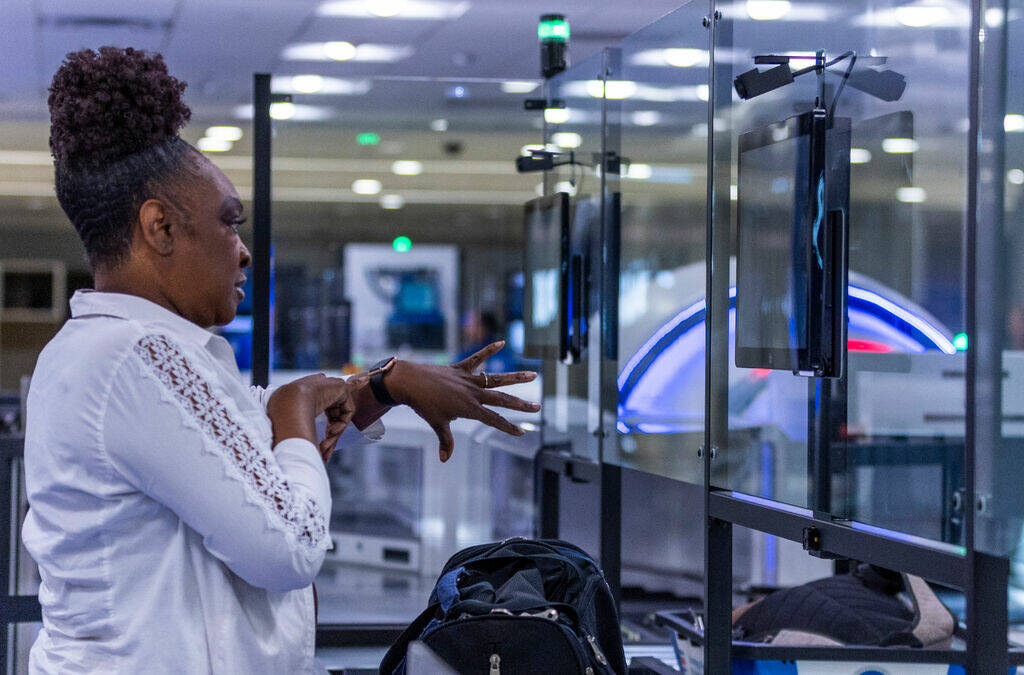 A Transportation Security Administration employee speaks with a TSA agent on screen as she demo ...