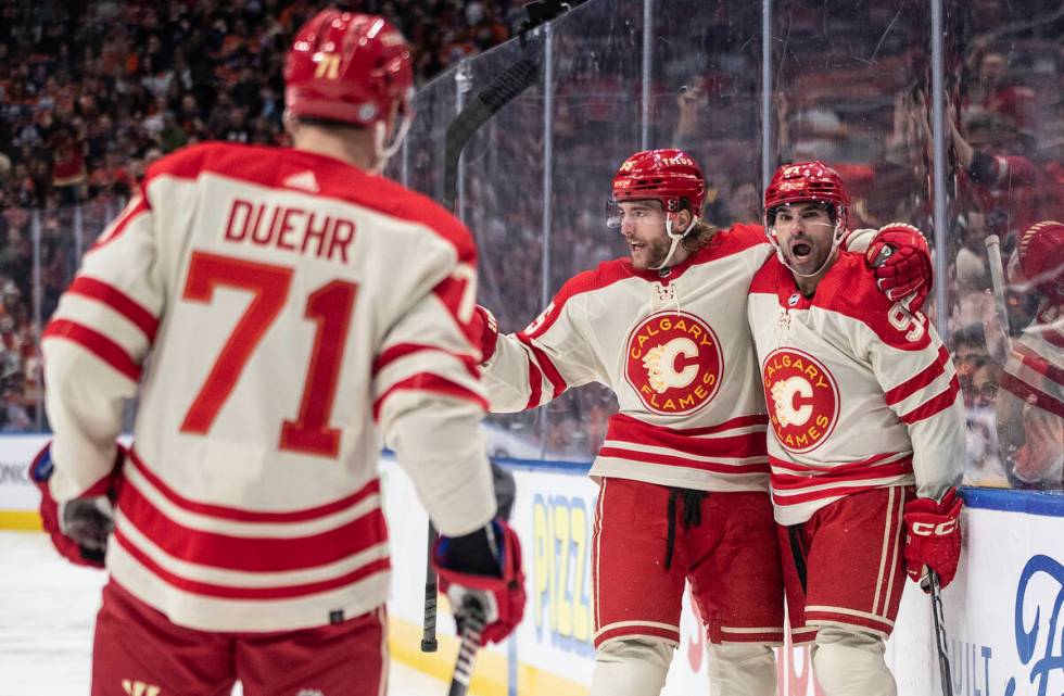 Calgary Flames' Walker Duehr (71), Noah Hanifin (55) and Nazem Kadri (91) celebrate after a goa ...