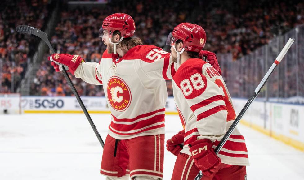 Calgary Flames' Noah Hanifin (55) and Andrew Mangiapane (88) celebrate after a goal against the ...