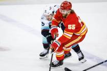 Seattle Kraken forward Jared McCann (19) checks Calgary Flames defenseman Noah Hanifin (55) dur ...