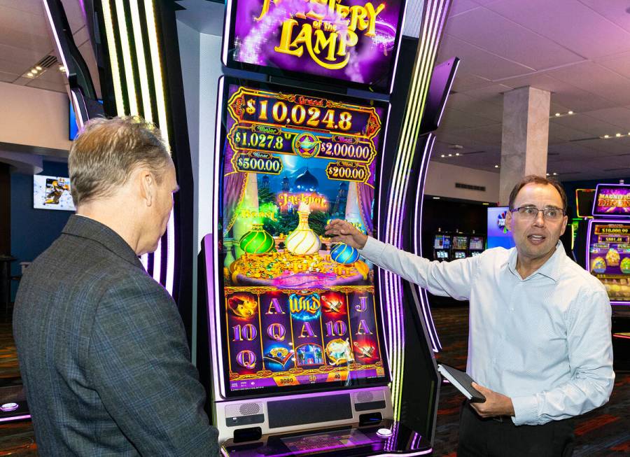 Nick Khin, right, a COO of Gaming for IGT, demonstrates how Mystery of the Lamp game is played ...