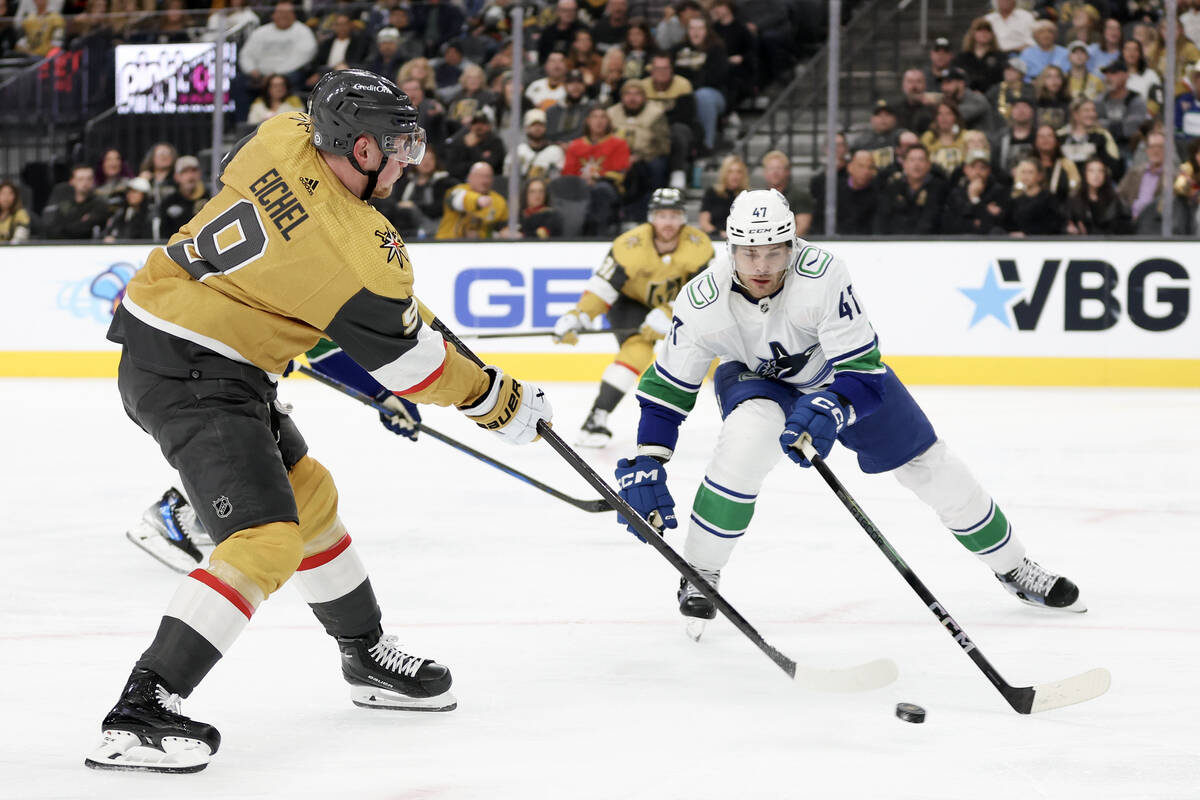 Golden Knights center Jack Eichel (9) attempts a goal while Canucks defenseman Noah Juulsen (47 ...