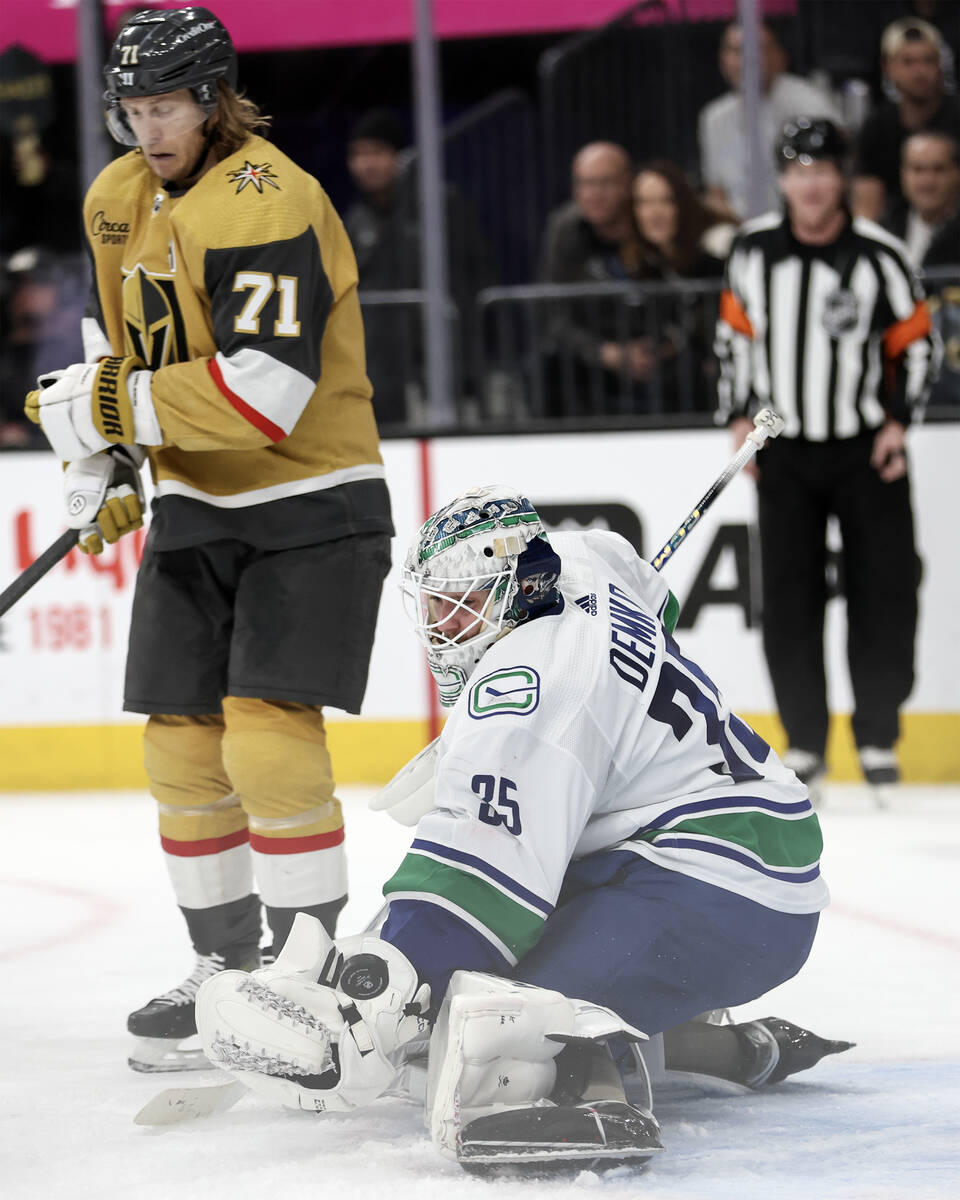 Canucks goaltender Thatcher Demko (35) saves the puck while Golden Knights center William Karls ...