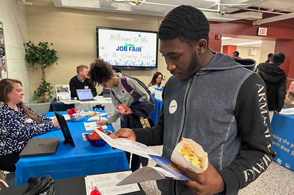 Job seeker Johannes Oveida looks over a brochure at a job fair at Lehigh Carbon Community Colle ...