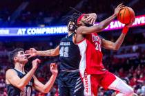 UNLV Rebels forward Keylan Boone (20) gets a hand to the face and a foul on the drive from UNR ...