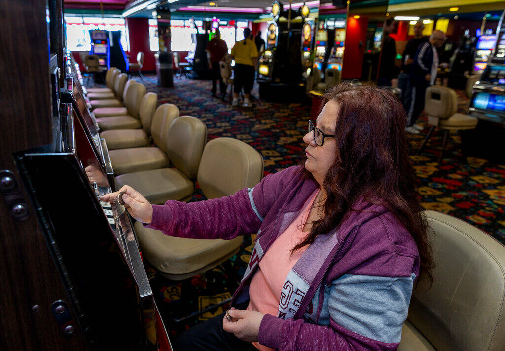 Wendy Womack of Texas inserts $1 coins into a machine in Slots A Fun, the revamped slots area h ...