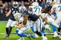 Los Angeles Chargers quarterback Easton Stick (2) is sacked by Raiders defensive tackle Jerry T ...