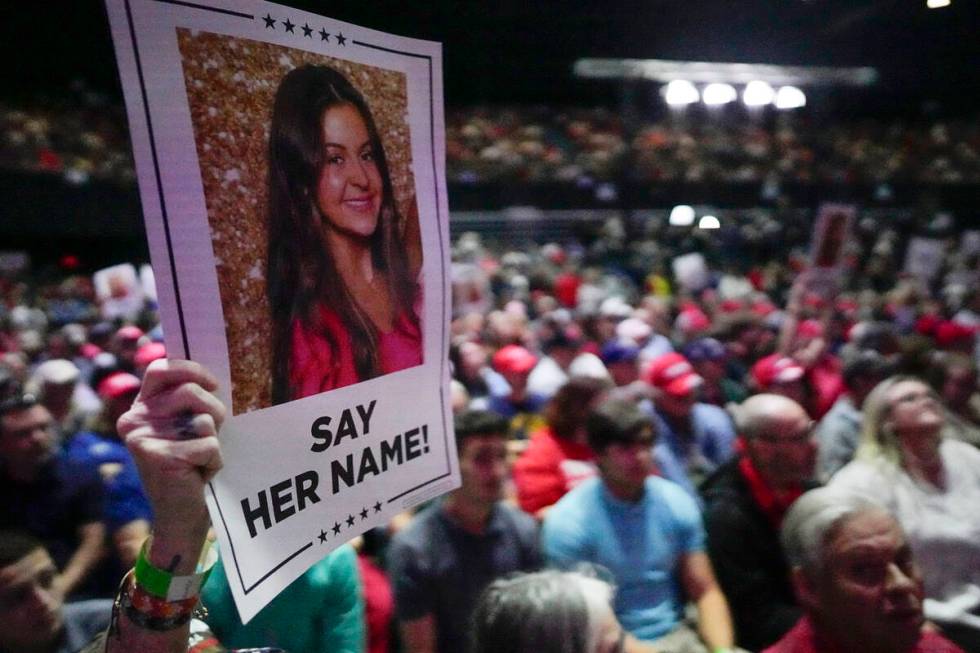 A supporter holds a oster with a photo of Laken Riley before Republican presidential candidate ...