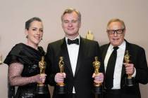 Emma Thomas, from left, Christopher Nolan, and Charles Roven pose in the press room with the aw ...