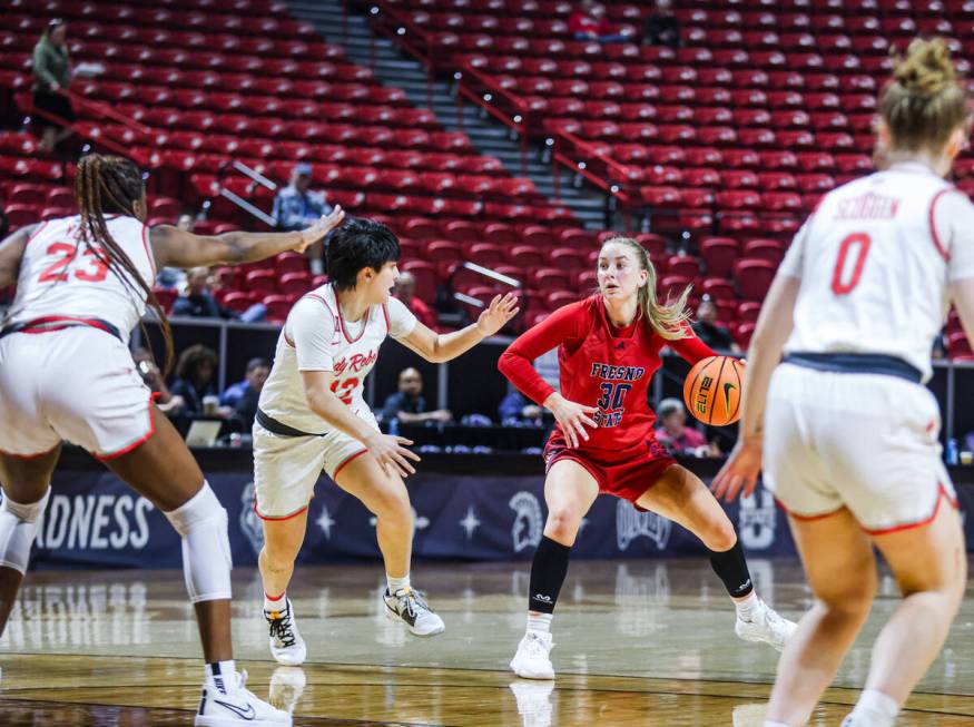 Fresno State’s forward Kylee Fox (30) looks to pass past UNLV’s guard Alyssa Dura ...